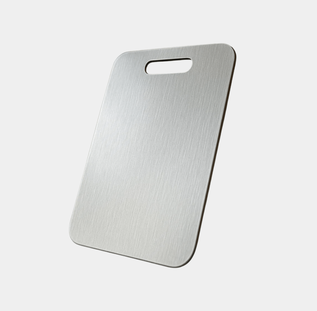 Brushed titanium cutting board with rounded corners and a top oval handle cutout