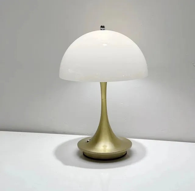 Brass finish table lamp with a white dome shade and a slender curved stem on a circular base.