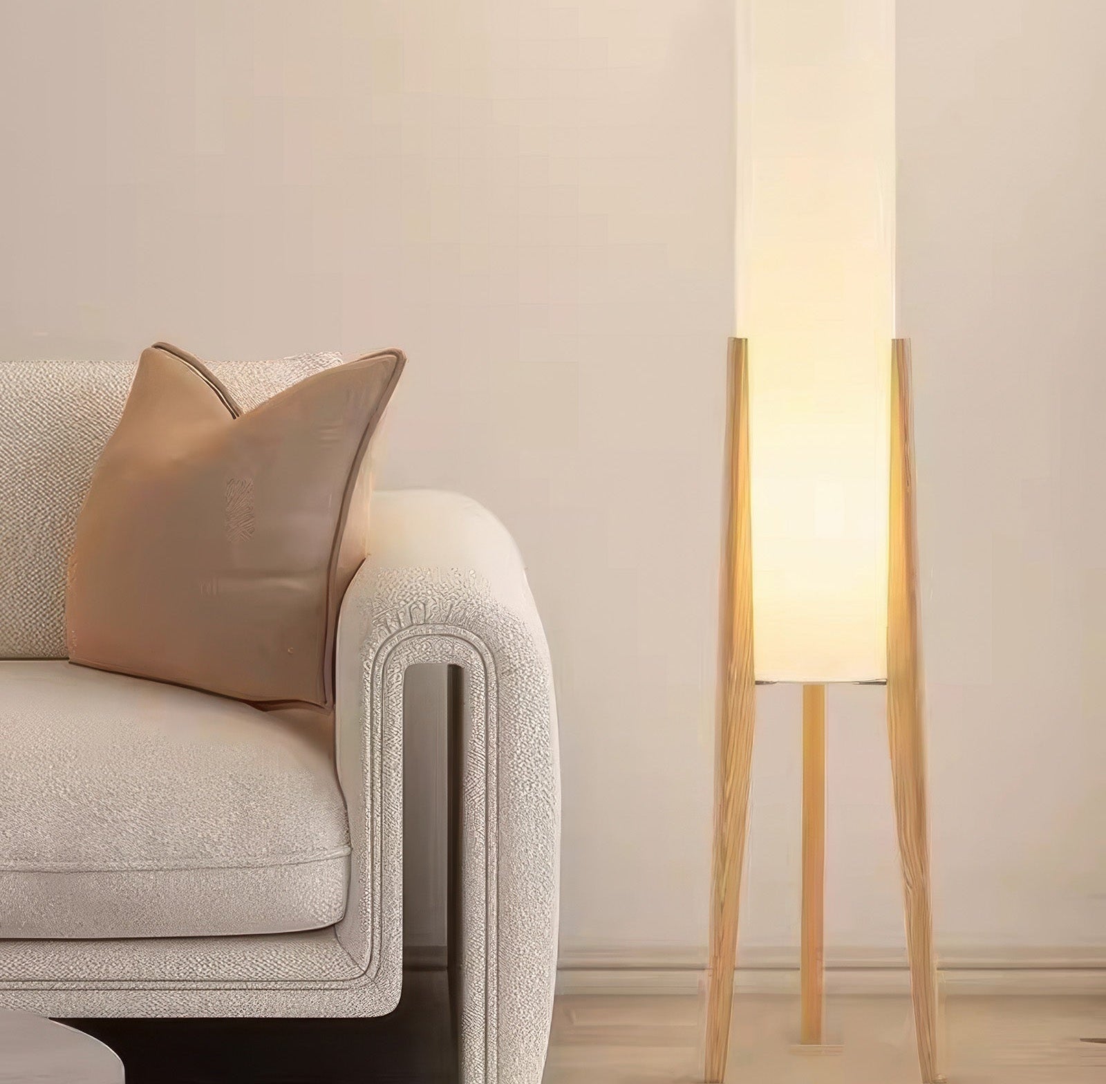 Kiyora Japandi floor lamp with solid walnut wood and fabric shade with brass accents beside a beige textured sofa and brown cushion in a softly lit living room