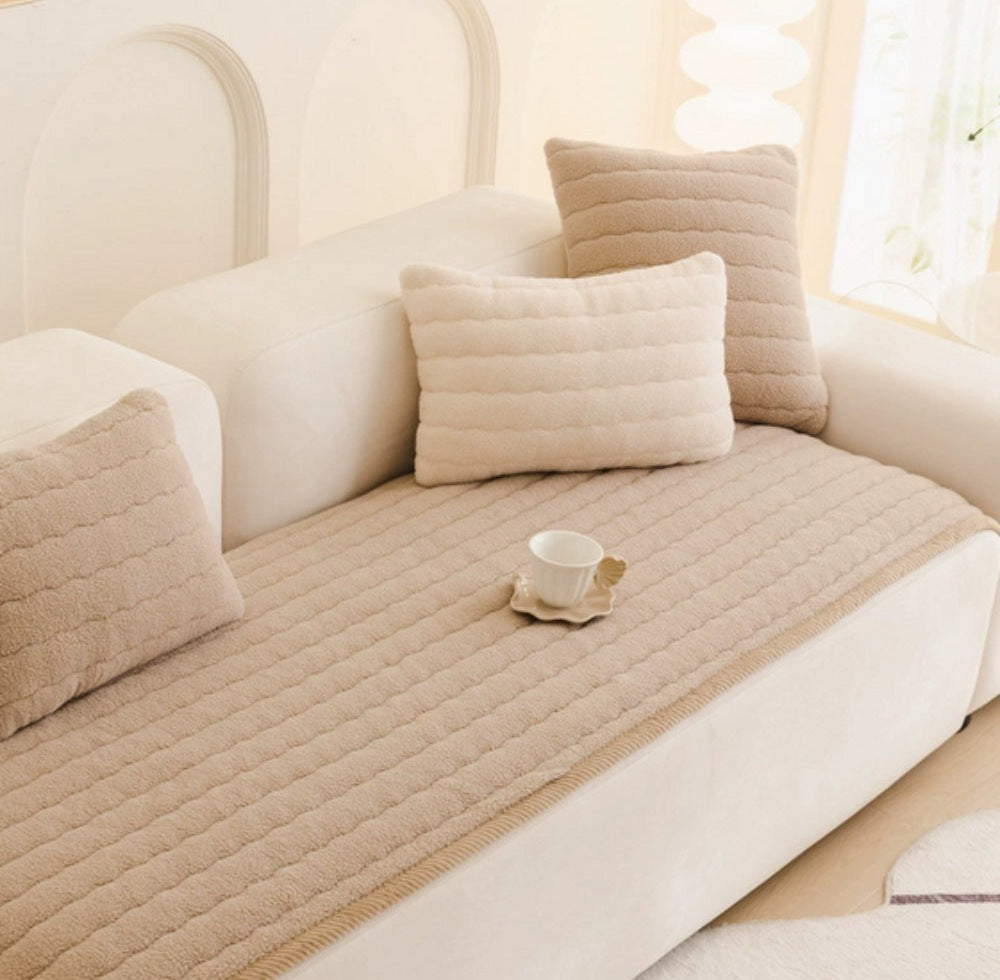 Beige ribbed plush sofa cover on a white sofa with beige and white cushions and a small cup on a saucer resting on the cover
