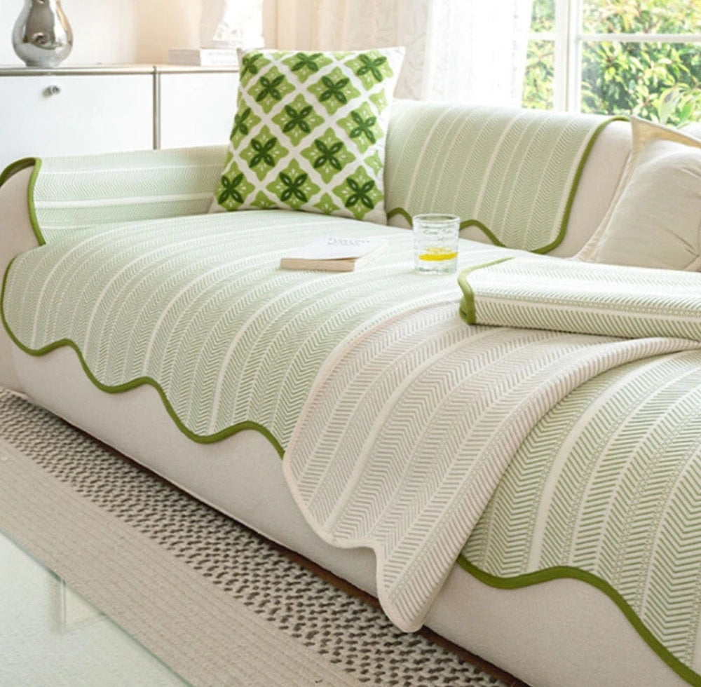 White sofa dressed with a light green herringbone microfiber cover with scalloped wave edge trim and a green patterned throw pillow