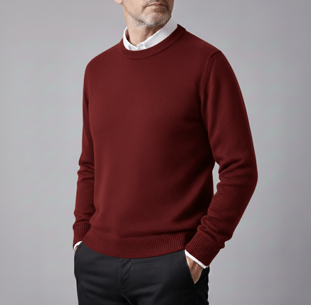 Man wearing a burgundy cashmere pullover sweater with a white collared shirt underneath and a classic crew neck.