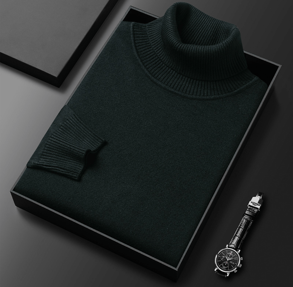 Dark green cashmere turtleneck sweater folded inside a black presentation box with a ribbed collar and a watch with a black leather strap beside it