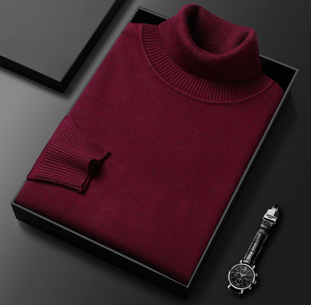 burgundy cashmere turtleneck sweater with ribbed collar folded inside a black box with a silver wristwatch resting on a dark surface