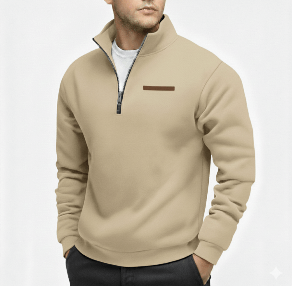 Man wearing a beige half zip fleece sweater with a zip collar and a small brown chest accent