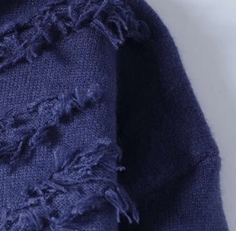 Close up of navy blue knit fabric with frayed fringe along the edge
