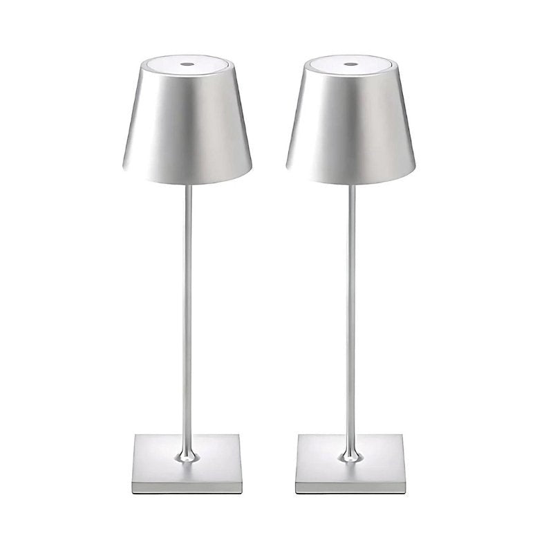 Two silver cordless table lamps with conical metal shades, slender stems and square bases.