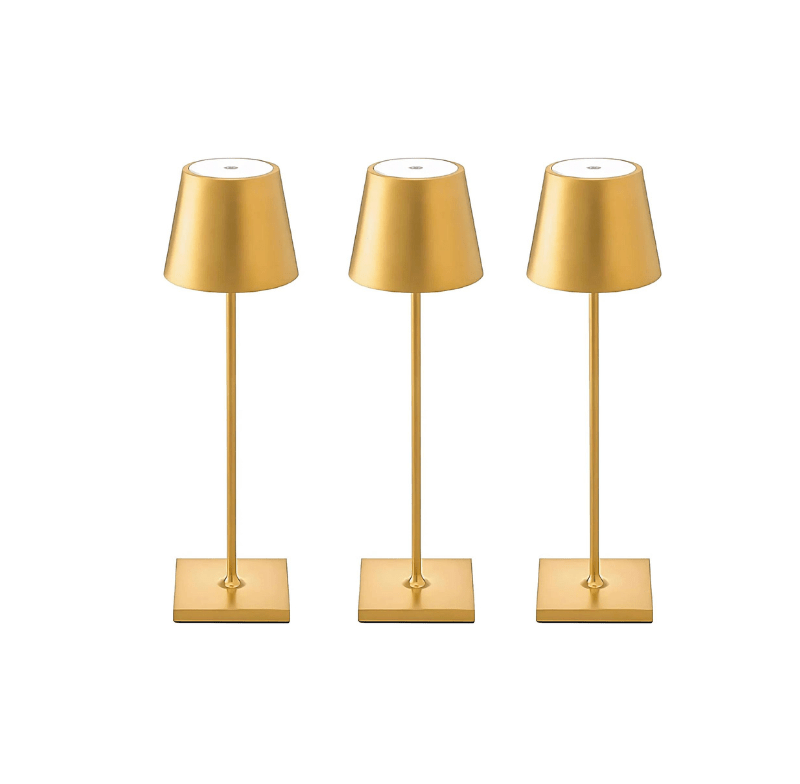 Three gold cordless table lamps with slender stems and square bases, each with a cone shaped shade on a white background