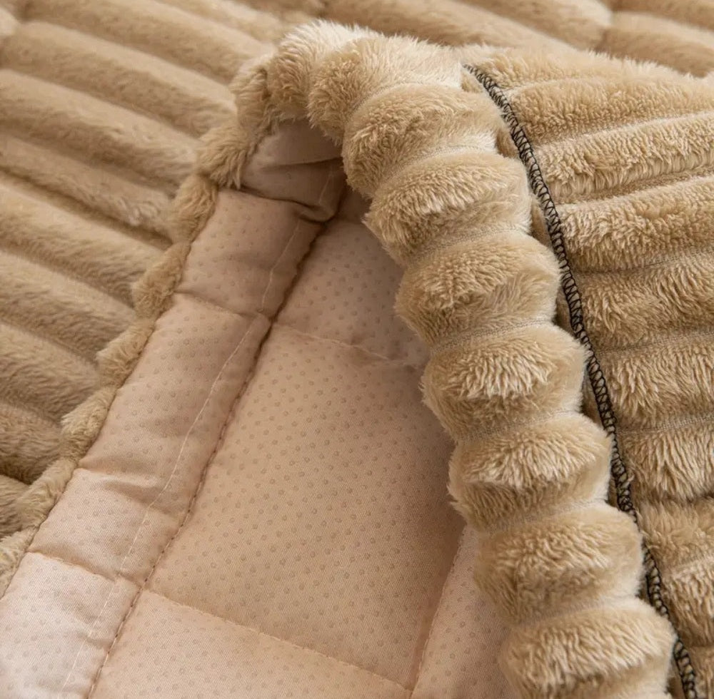 Close up of a beige Veloura sofa cover showing a fluffy pom pom edge and a dotted soft inner lining