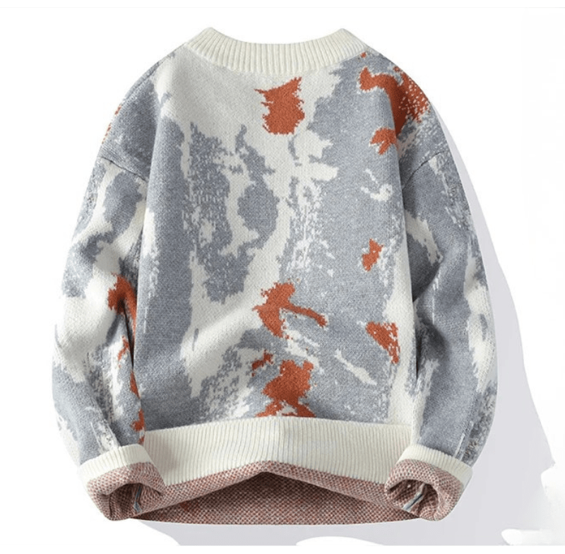 Knit sweater with an abstract gray and white pattern and orange accents, cream ribbed neckline and hem