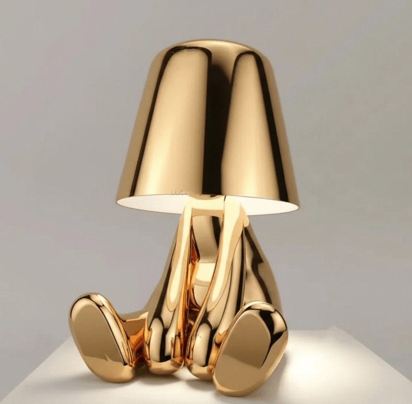 Gold aluminum table lamp with a sculptural glossy base and a small gold shade