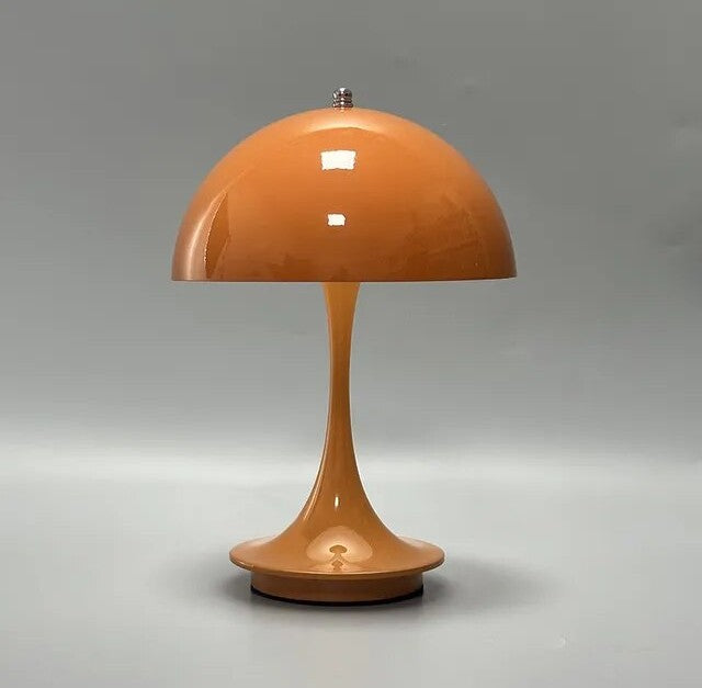 Orange glossy dome table lamp with a slender curved stem and round base on a light gray background