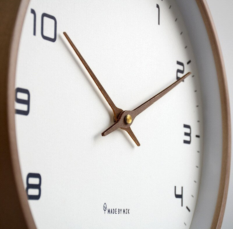 Nordic minimalist wall clock with a white dial, black numerals, copper brown hands, and a brown wooden frame with Made by MTK at the bottom