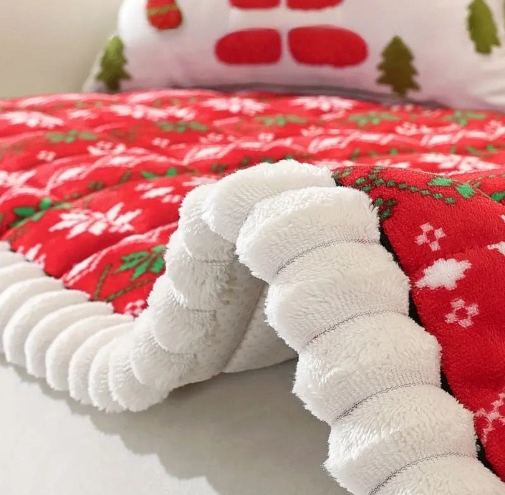 Close up of a white fluffy segmented cushion on a red festive sofa cover with white snowflakes and green holly, with a holiday themed pillow in the background