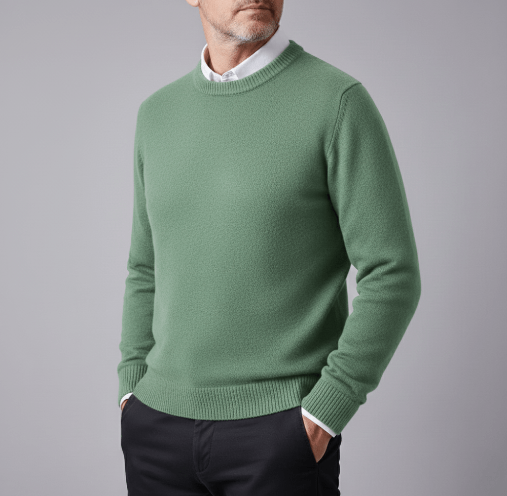 Montclair green cashmere pullover sweater with a classic crew neck worn over a white shirt, paired with dark pants.