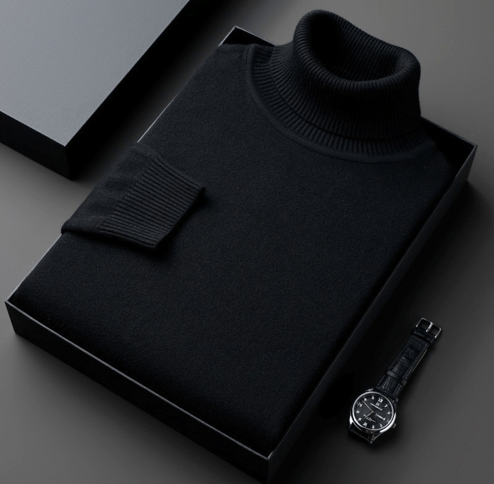 Montclair black turtleneck sweater with a ribbed collar folded in a black box with a wristwatch beside it on a gray background