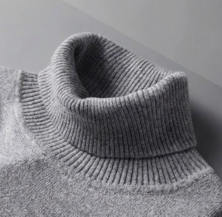 Close up of a gray cashmere turtleneck sweater with a ribbed collar