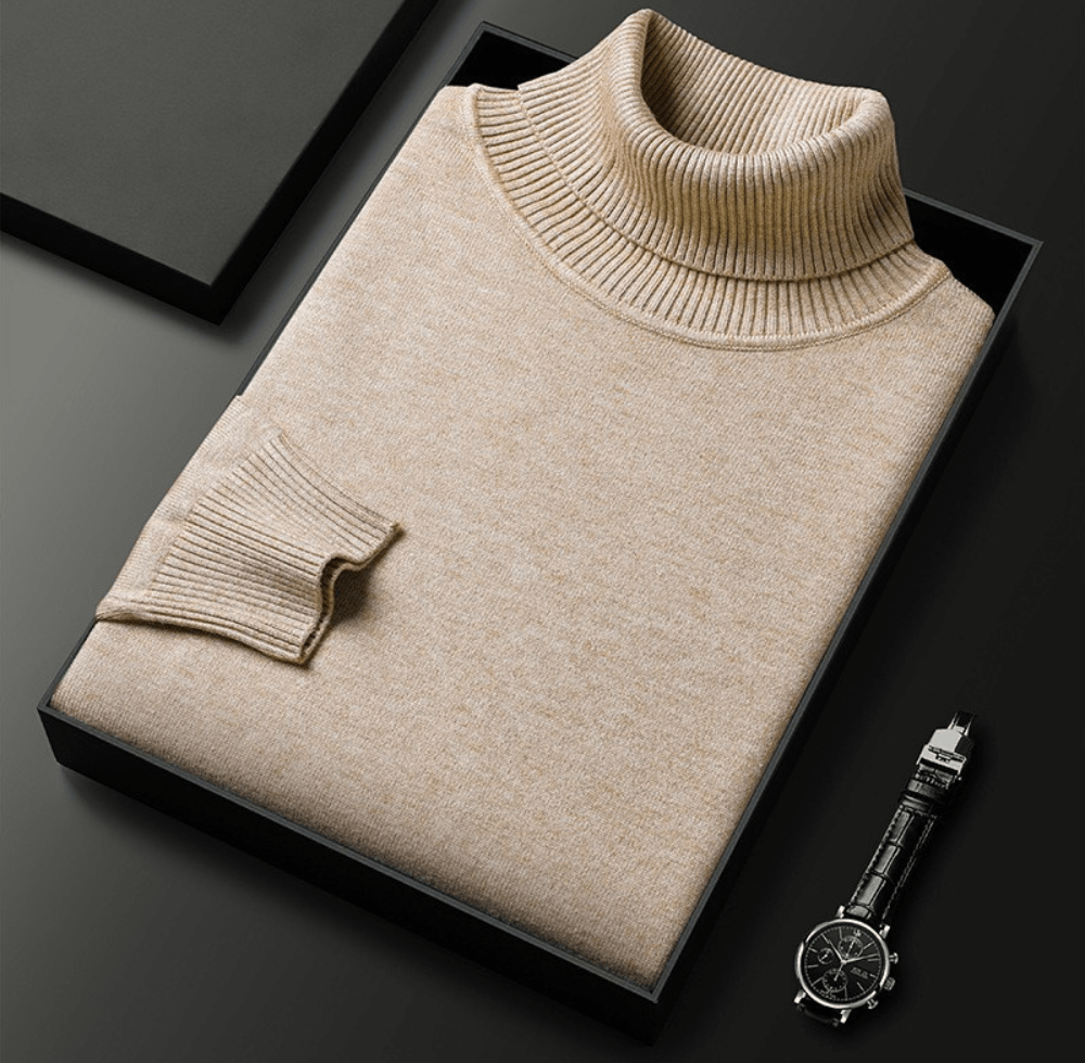 Beige cashmere turtleneck sweater with a ribbed collar folded inside a black gift box, with a black chronograph watch placed beside it.