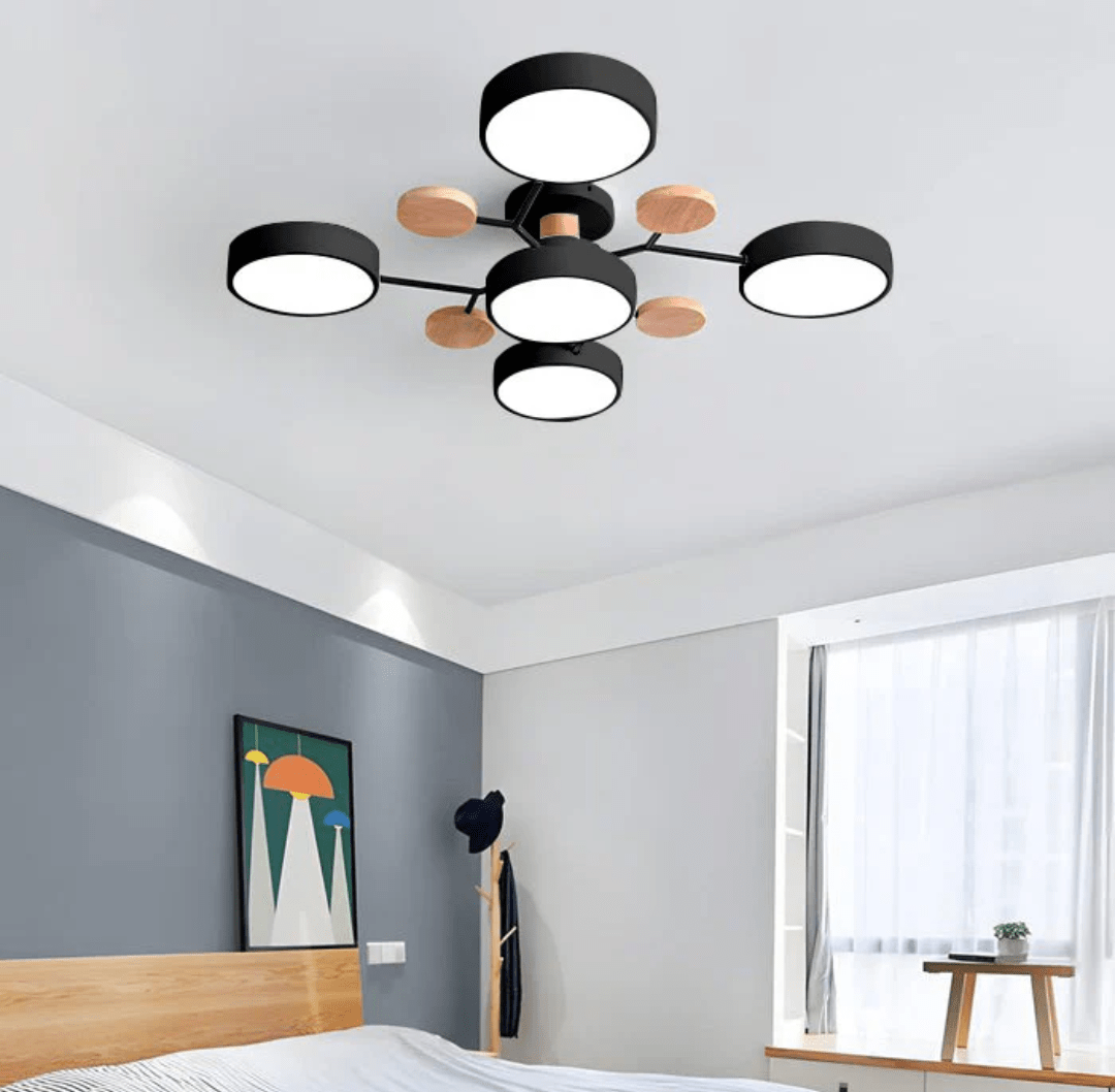 Nordhaven LED ceiling light with a black iron frame and wooden accents featuring five circular white panels in a minimalist design installed in a modern bedroom