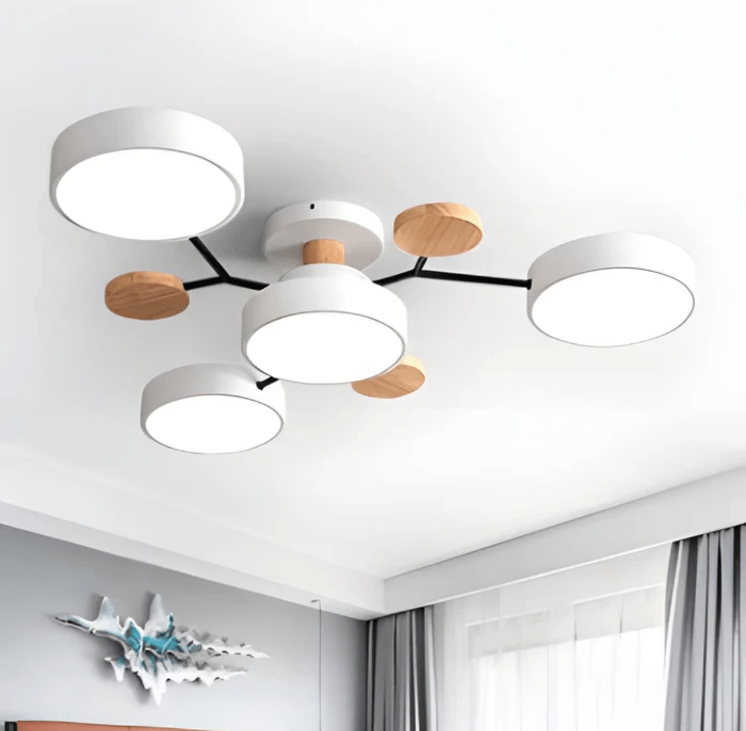 Modern ceiling light fixture with five round white LED discs on black arms and wooden accents mounted to the ceiling