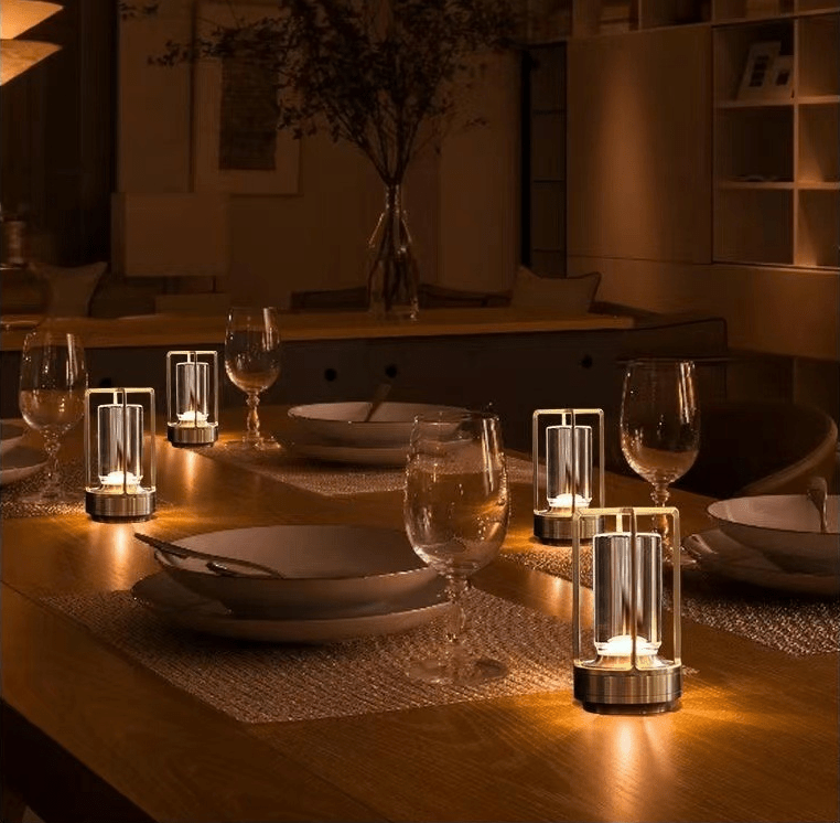 Solaran cordless lantern table lamps with crystal glass and metal frames glow on a dining table set with plates and wine glasses, featuring touch sensor dimming.